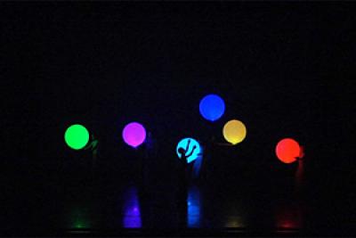 Dancers interact with illuminated inflatable balls Dancers interact with illuminated inflatable balls
