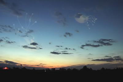 Still from The Approach showing a twighlight landscape with puffy clouds and jelly fish in the sky Still from The Approach showing a twighlight landscape with puffy clouds and jelly fish in the sky